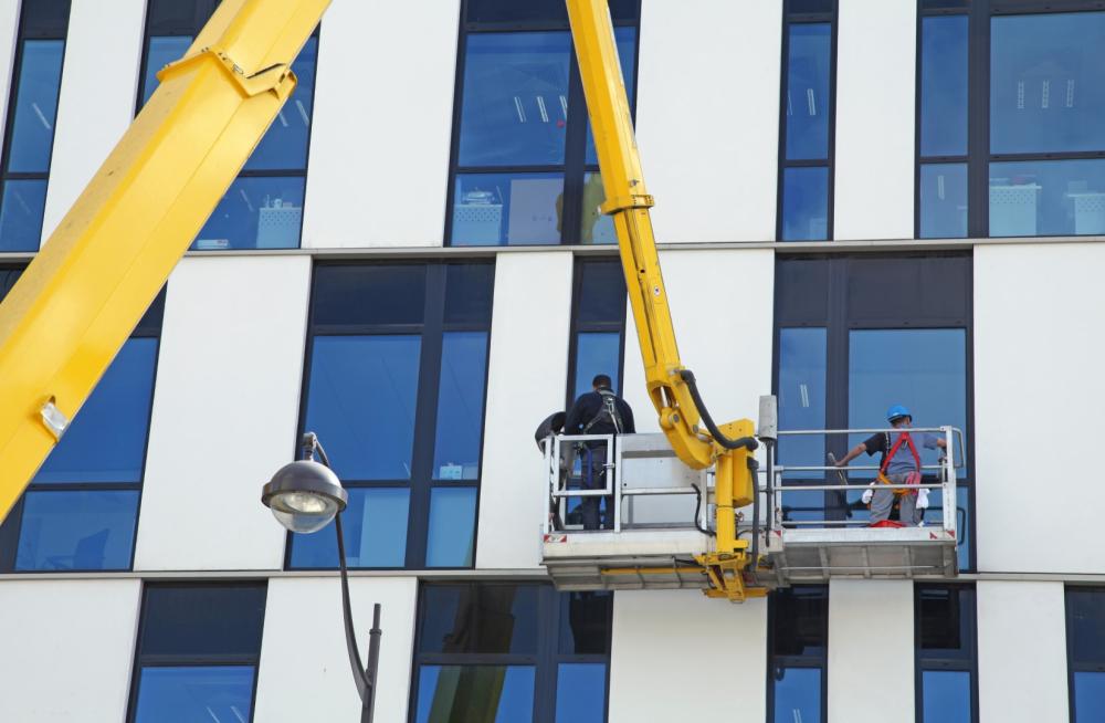 personnes sur nacelle nettoyant les vitres extérieures d'un bâtiment